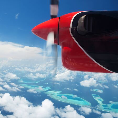 Tropical islands, view from hydroplane. Clouds in the blue sky, flight under islands in the oceanの写真素材