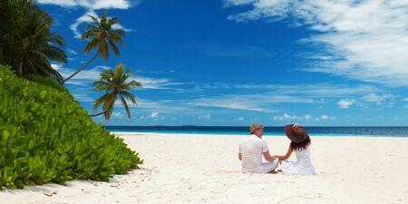 Happy honeymoon vacation at summer. Couple relax on the white sand of beach. Happy sea lifestyle. Young family, man and woman rest on the beach of ocean. Couple in love travel to island. Love travelの写真素材