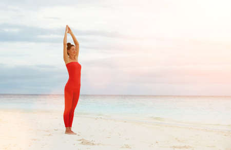 Yoga outdoor. Happy woman doing yoga exercises, meditate on the beach. Yoga meditation in nature. Concept of healthy lifestyle and relaxation. Pretty woman practicing yoga near the seaの写真素材