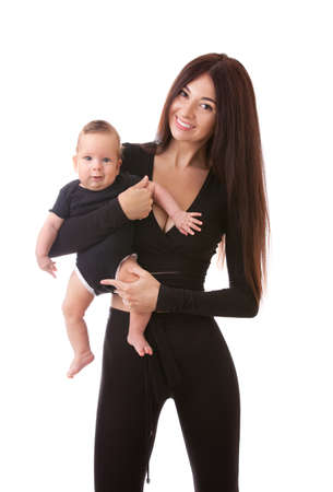 Portrait of mother and her little child in black. Happy family concept. Mother holding cute baby isolated on white background. . Motherhood and children concept. Close upの写真素材