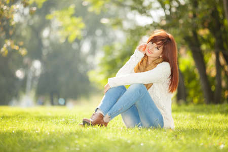 Young woman walking in the park. Beauty nature scene with colorful background at autumn season. Outdoor lifestyle. Happy smiling woman relax at fallの写真素材