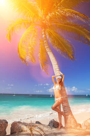 Fashion woman walking on the beach. Happy beach lifestyle. White sand, blue sky and crystal sea of tropical beach. Vacation at Paradise. Ocean beach relax, travel to oceanの写真素材