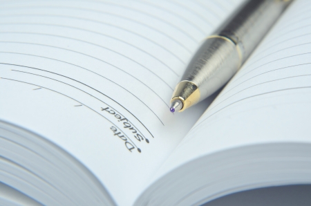 Open note book with pen, isolated on whiteの写真素材