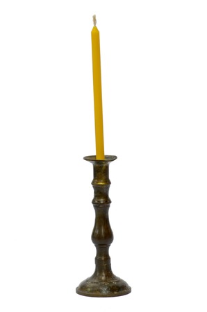 Old golden holder with yellow candle isolaated on white backgroundの写真素材