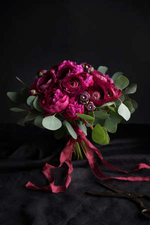 Red bouquet of the bride on a dark background, Selective focusの写真素材