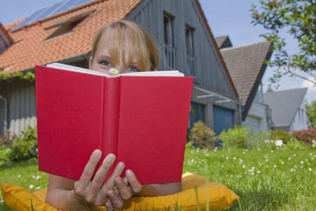 blonde women in garden in front of house with solar panelsの写真素材