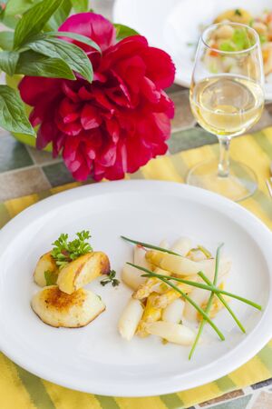 fried asparagus salad and roast potatoesの写真素材