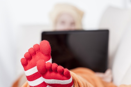 woman in warm toe socks and blanket at homeの写真素材