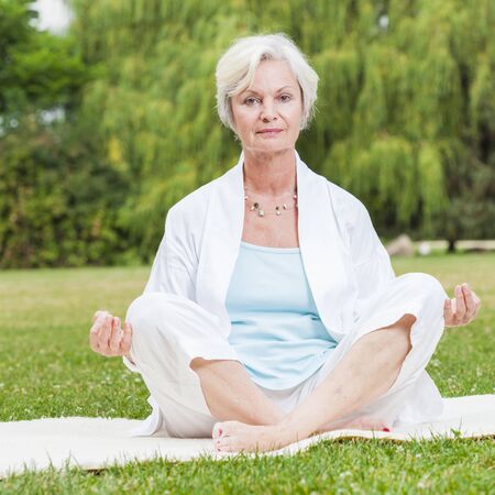 best ager women practising yoga and tai chi outdoorsの写真素材