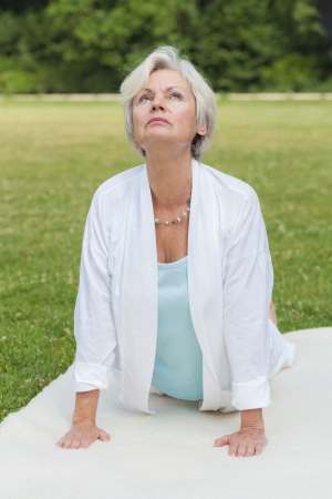 best ager women practising yoga and tai chi outdoorsの写真素材