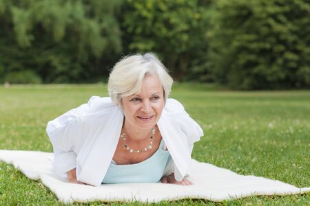 best ager women practising yoga and tai chi outdoorsの写真素材