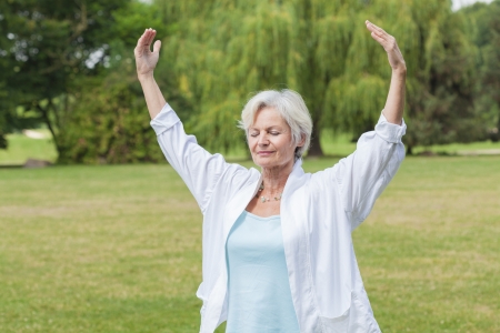 best ager women practising yoga and tai chi outdoorsの写真素材