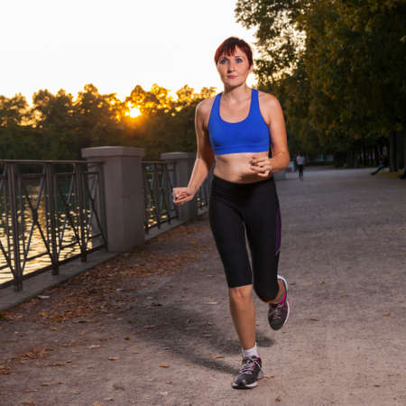 beautiful young women running in a park at sunrise or sunset