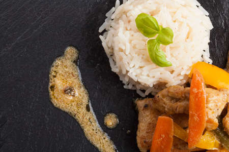 healthy fresh home made asian chicken rice dish on black slate plateの写真素材
