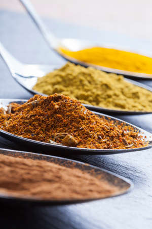 oriental indian spices curry paprika nutmeg on slateの写真素材