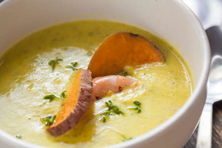 curry sweet potato soup with shrimp on vintage tableの写真素材