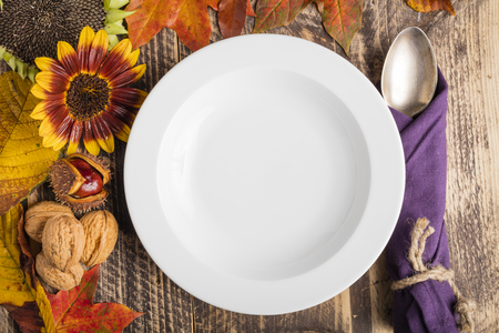 autumn fall decorated rustic wooden classy table white plate text spaceの写真素材