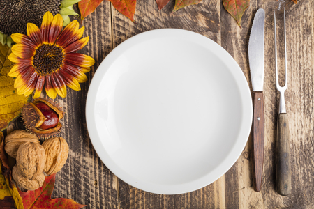 autumn fall decorated rustic wooden classy table white plate text spaceの写真素材
