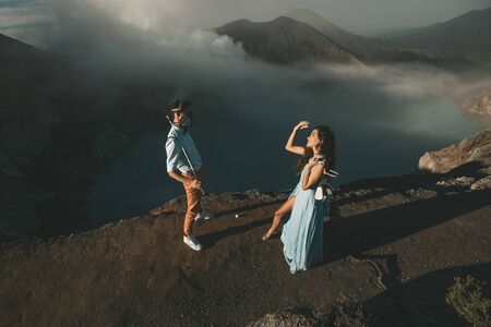 Couple in love stand in protective masks with views of the mountainsの写真素材