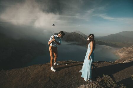 Man and woman are standing on the edge of the craterの写真素材