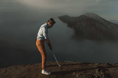 Man tourist in protective mask on the edge of the crater of volcanoの写真素材