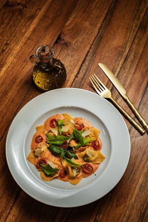 Tortellini pasta in red tomato sauce with basil and parmesan cheese.の写真素材