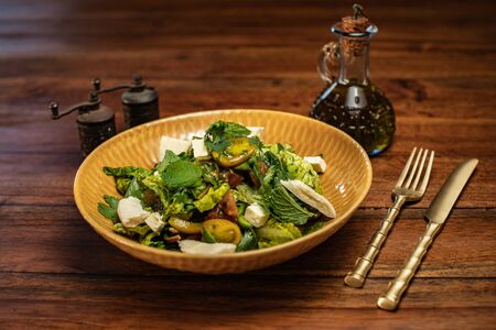 Vegetable salad with feta cheese on top of a wooden tableの写真素材