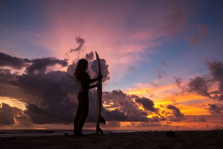 surf girl meets sunset on the beach. silhouette