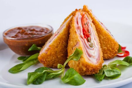 Cordon blue with sauce on white plate