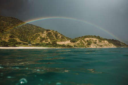 A rainbow over a body of waterの写真素材