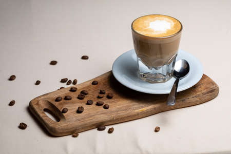 Coffee cup and beans on old kitchen table Cappuccino hot coffee with milk cupの写真素材