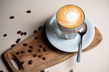 Coffee cup and beans on old kitchen table Cappuccino hot coffee with milk cupの写真素材