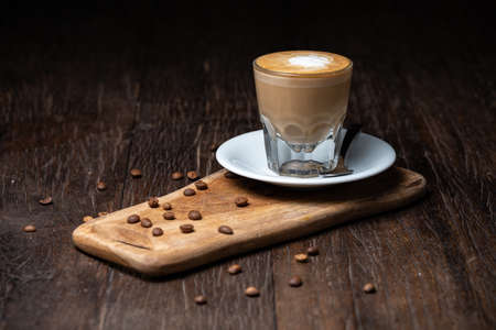 Coffee cup and beans on old kitchen table Cappuccino hot coffee with milk cupの写真素材