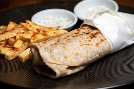 Shawarma, Doner-kebab, Lavash with barbecue on a black plate Durum Gyros Brtuchの写真素材