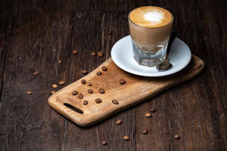 Coffee cup and beans on old kitchen table Cappuccino hot coffee with milk cupの写真素材