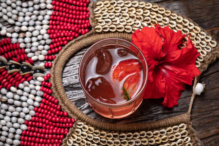 Strawberry iced tea, strawberry daiquiri with ice in a glass, red flowerの写真素材