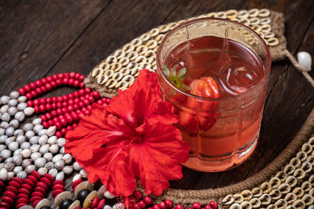 Strawberry iced tea, strawberry daiquiri with ice in a glass, red flowerの写真素材