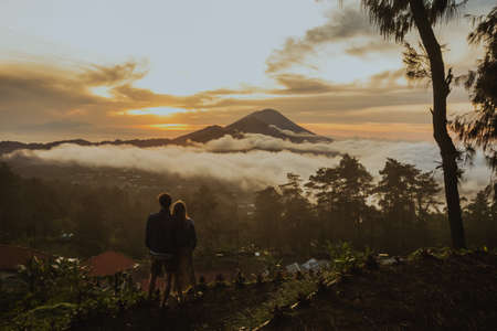 A loving couple, a man and a woman stands near Batur volcano. Sunrise, sunsetの写真素材