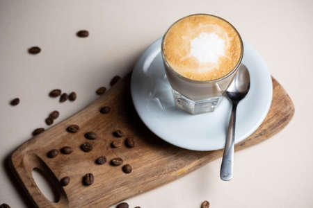 Coffee cup and beans on old kitchen table Cappuccino hot coffee with milk cupの写真素材