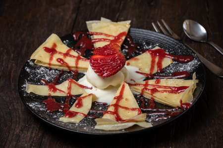 Crepe or fine pancake with pieces strawberry and vanilla ice cream. Whip creamの写真素材