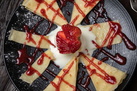 Crepe or fine pancake with pieces strawberry and vanilla ice cream. Whip creamの写真素材