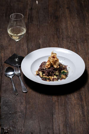 Traditional Spanish seafood paella on a dark wooden table with white wine Veganの写真素材