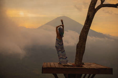 Girl in a long dress stands with Bali landmark volcano Agung view. Sunsetの写真素材