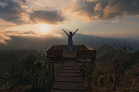 Girl in a long dress stands with Bali landmark volcano Agung view. Sunsetの写真素材