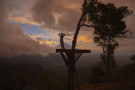 Girl in a long dress stands with Bali landmark volcano Agung view. Sunsetの写真素材