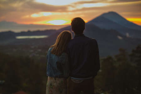 A loving couple, a man and a woman stands near Batur volcano. Sunrise, sunsetの写真素材