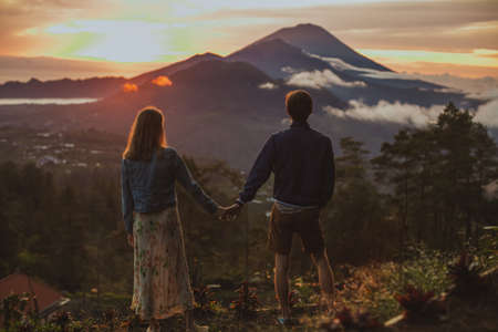 A loving couple, a man and a woman stands near Batur volcano. Sunrise, sunsetの写真素材