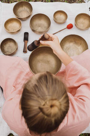 Young woman with white hair in a pink kimono plays on a singing bowlの写真素材