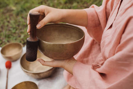 Young woman with white hair in a pink kimono plays on a singing bowlの写真素材