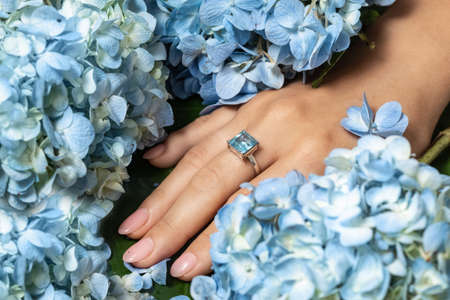Fashion silver or white gold ring with a blue aquamarine stone on hand. Jewelry.の写真素材